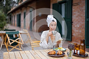 Woman having breakfast at hotel terrace on nature