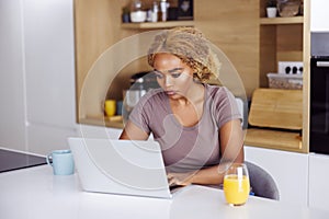 Woman having breakfast and working remotely from home