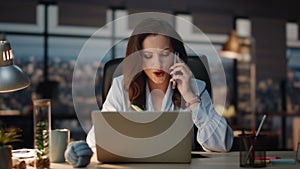 Woman having business call writing notes at office. Smiling lady boss talking