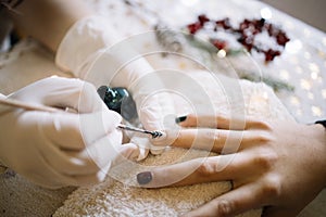 Woman having Christmas nail manicure at beauty salon