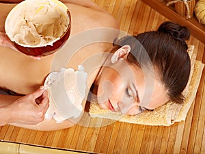 Woman having clay body mask.