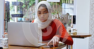 Woman having coffee while using laptop and mobile phone 4k