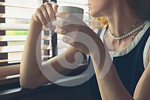 Woman having coffee by the window in a diner