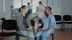 Woman having conversation with nurse in waiting area