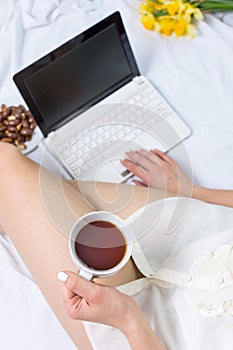 Woman having a cup of tea in bed