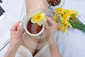 Woman having a cup of tea in bed