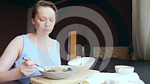 Woman having dinner while sitting at the table indoors