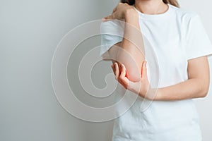 Woman having elbow ache at home, muscle pain due to lateral epicondylitis or tennis elbow. injury, Health and medical concept