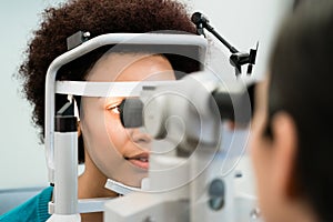 Woman having eyes measured with refractometer