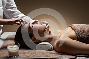 Woman having face and head massage at spa