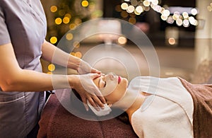Woman having face and head massage at spa parlor