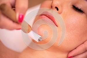 Woman having a facial madero therapy with face roller