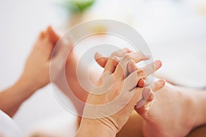 Woman having foot reflexology massage in salon