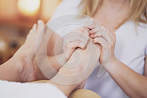 Woman having foot reflexology massage in salon