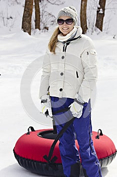 Woman having fun going snow tubing on a winter day