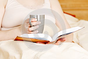 Woman having a glass of red wine in bed, stay home