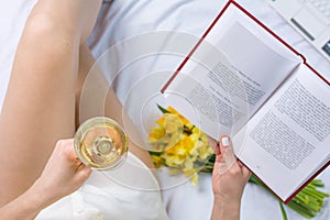 Woman having a glass of wine in bed