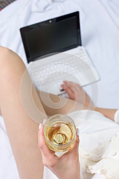 Woman having a glass of wine in bed