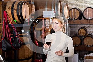 Woman having glass of wine in wine house