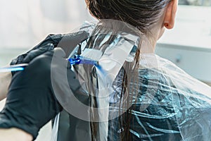 Woman having hair foiled while coloring in hair salon