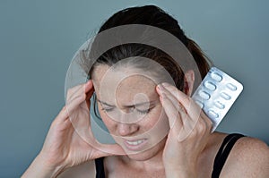 Woman having headache taking pills