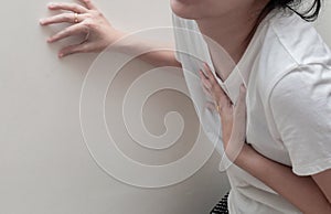 Woman having heart attack, chest pain, or heartburn from GERD, isolated in white background. People with heart problem or GERD con