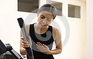 Woman having heart attack on treadmill in gym