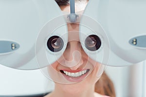 Woman having her eyesight measured with phoropter