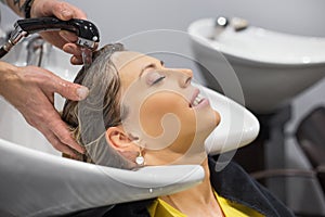 Woman having her head washed by hairdresser