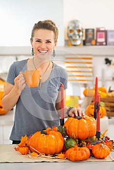 Woman having hot beverage in Halloween decorated kitchen