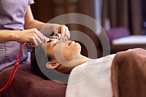 Woman having hydradermie facial treatment in spa photo