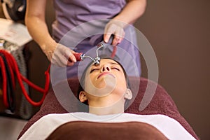 Woman having hydradermie facial treatment in spa photo