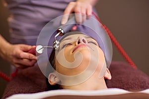 Woman having hydradermie facial treatment in spa photo