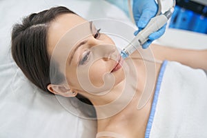 Woman having hydrafacial skincare procedure in beauty salon