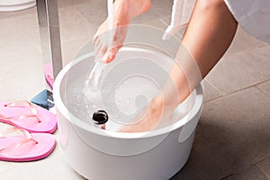 Woman having hydrotherapy water footbath