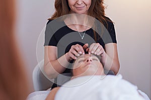 Woman having japan style face massage in salon