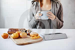 Woman having lunch with her friend, gossiping and enjoying chit-chat. Ordinary slender woman drinking coffee, watching