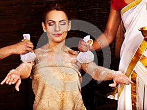 Woman having massage with pouch of rice.