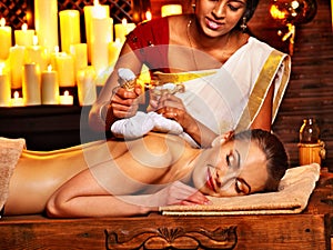 Woman having massage with pouch of rice.
