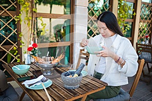 Woman having a meal of thai food with tom yum soup in a restaurant