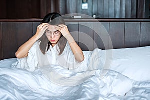 Woman having migraine headaches during lying in bed at home. insomnia, sleepless, tired, suffering and stressed concepts