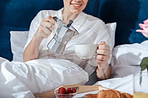 Woman having morning coffee in bed