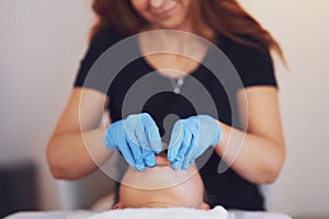 Woman having mouth massage in blue gloves