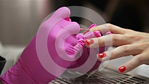 Woman Having a Nail Manicure In a Beauty Salon With a Close Up View Of a Beautician Applying Varnish With An Applicator