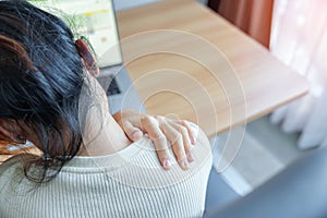 Woman having Neck and Shoulder pain during work long time on workplace. due to fibromyalgia, rheumatism, Scapular pain, office