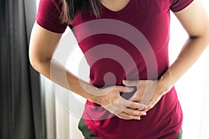 Woman having painful stomachache at home. Chronic gastritis. Abdomen bloating concept