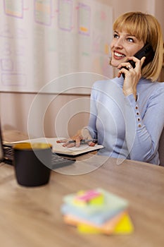 Woman having phone conversation while working
