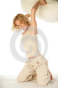 Woman having pillow fight in bed