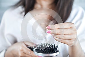 Woman having problem with hair loss hand holding hair fall on comb