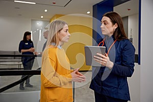 Woman having quick consultation with gynecologist in clinic corridor photo